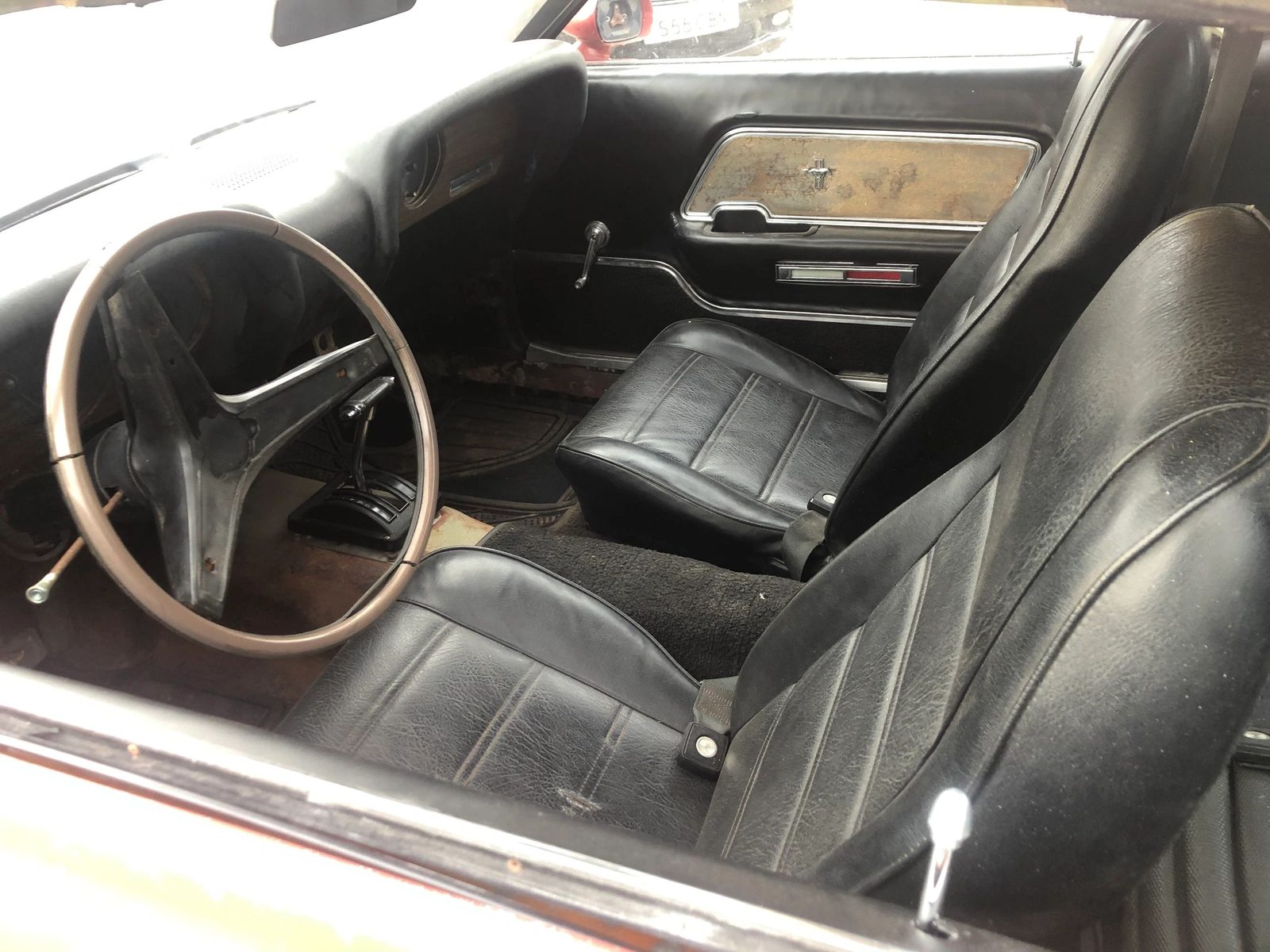 Black vinyl bucket seats, steering wheel and door card inside the Mach 1